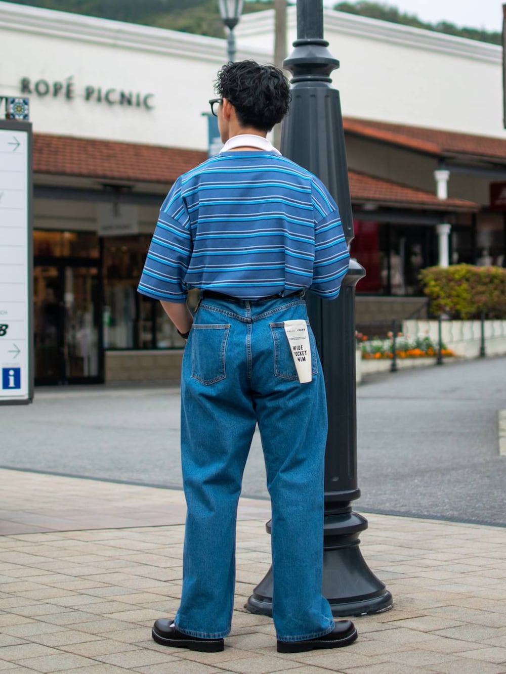 ブルー系のデニムパンツ、ブルー系のTシャツ/カットソー、ブラック系のその他シューズを着用したメンズの春コーディネートの4枚目の写真