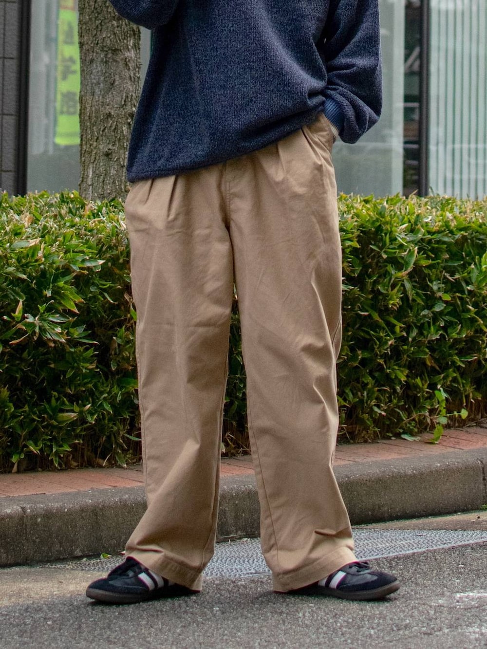 ブルー系のシャツ/ブラウス、ベージュ系のチノパンツ、ブラック系のスニーカーを着用したメンズの冬コーディネートの6枚目の写真