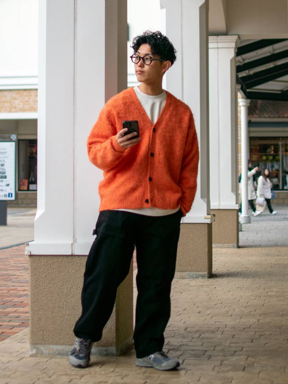 ブラック系のデニムパンツ、ホワイト系のスウェット、オレンジ系のカーディガン/ボレロを着用したメンズの冬コーディネートの2枚目の写真