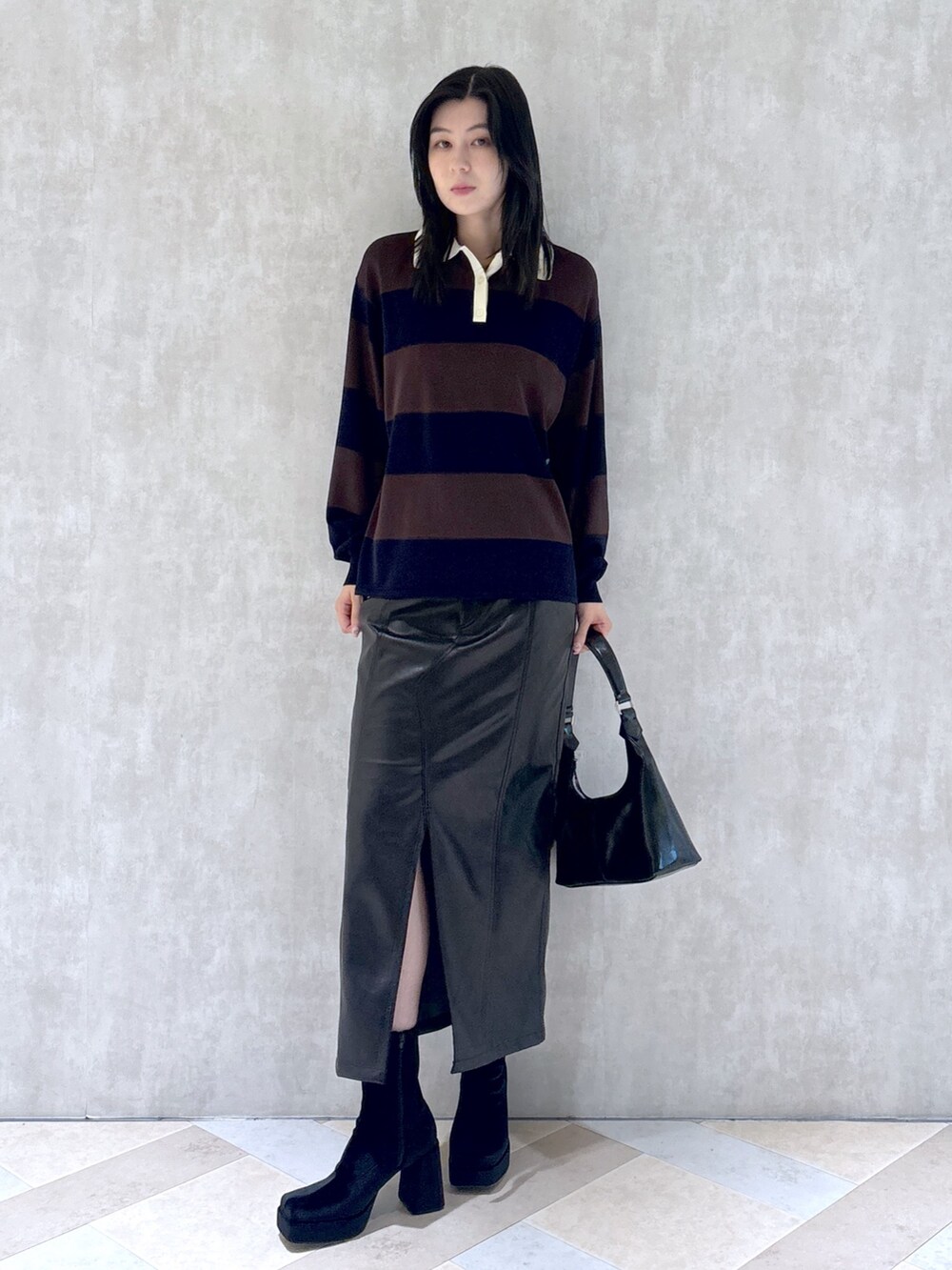 ブラウン系のニット/セーター、ブラック系のスカート、ブラック系のショルダーバッグを着用したレディースの秋コーディネートの2枚目の写真