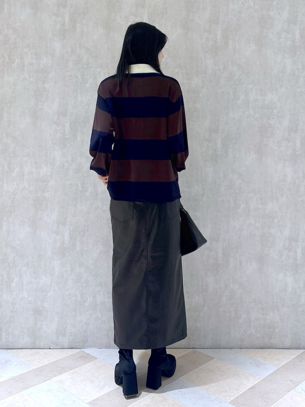 ブラウン系のニット/セーター、ブラック系のスカート、ブラック系のショルダーバッグを着用したレディースの秋コーディネートの5枚目の写真