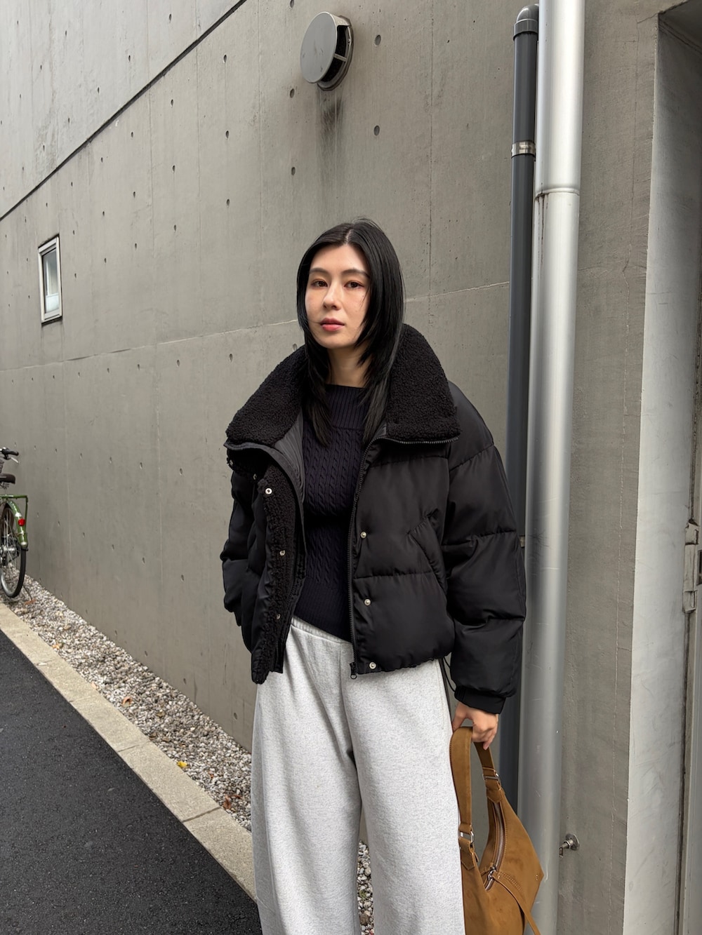 ブラック系のダウンジャケット/コート、グレー系のスウェットパンツ、ブラック系のブーツを着用したレディースの秋コーディネートの3枚目の写真