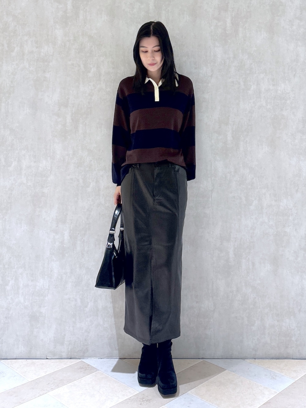 ブラウン系のニット/セーター、ブラック系のスカート、ブラック系のショルダーバッグを着用したレディースの秋コーディネートの3枚目の写真