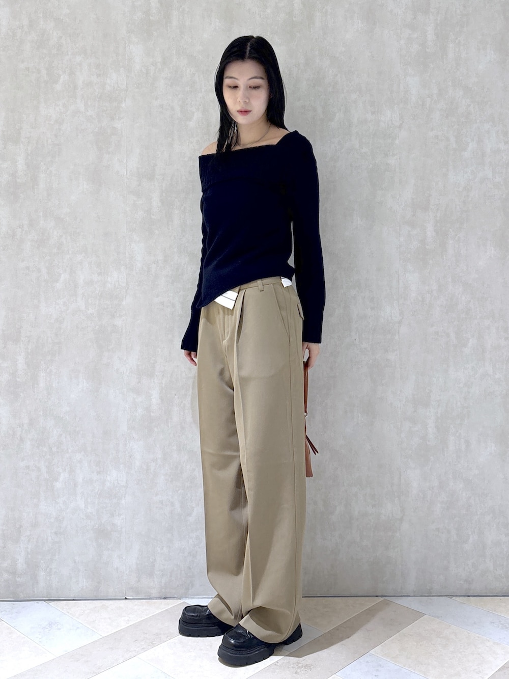 ブルー系のニット/セーター、ベージュ系のその他パンツ、ブラック系のローファーを着用したレディースの秋コーディネートの3枚目の写真