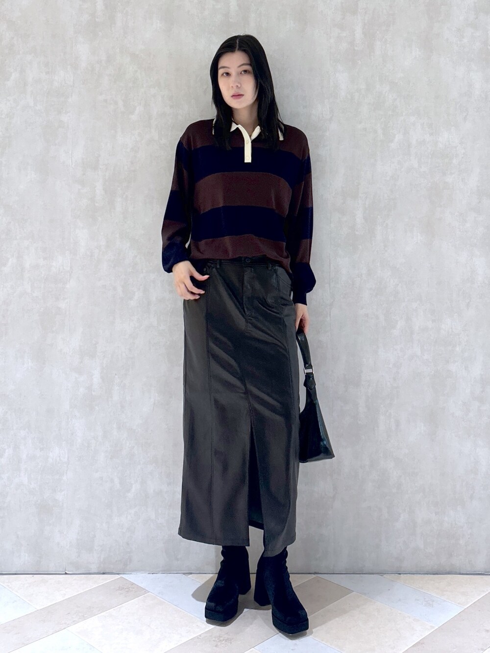 ブラウン系のニット/セーター、ブラック系のスカート、ブラック系のショルダーバッグを着用したレディースの秋コーディネートの4枚目の写真