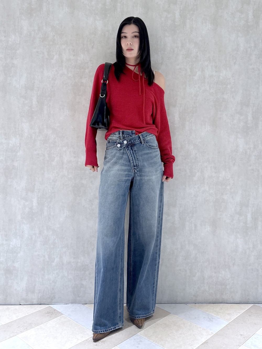 レッド系のニット/セーター、ブルー系のデニムパンツ、ブラウン系のパンプスを着用したレディースの秋コーディネートの4枚目の写真