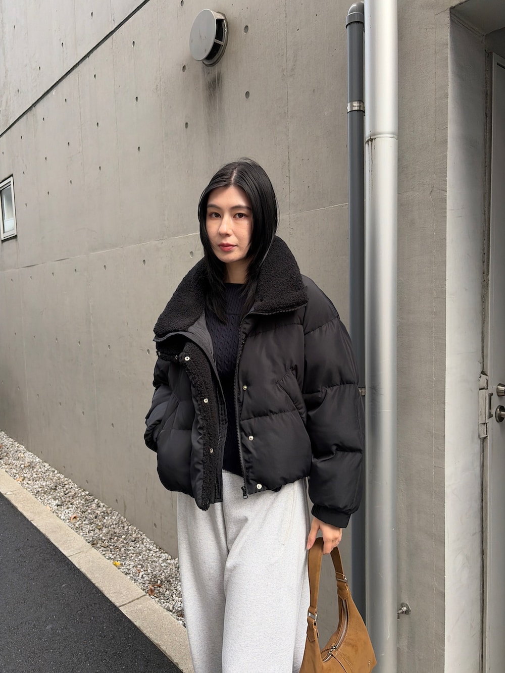 ブラック系のダウンジャケット/コート、グレー系のスウェットパンツ、ブラック系のブーツを着用したレディースの秋コーディネートの4枚目の写真