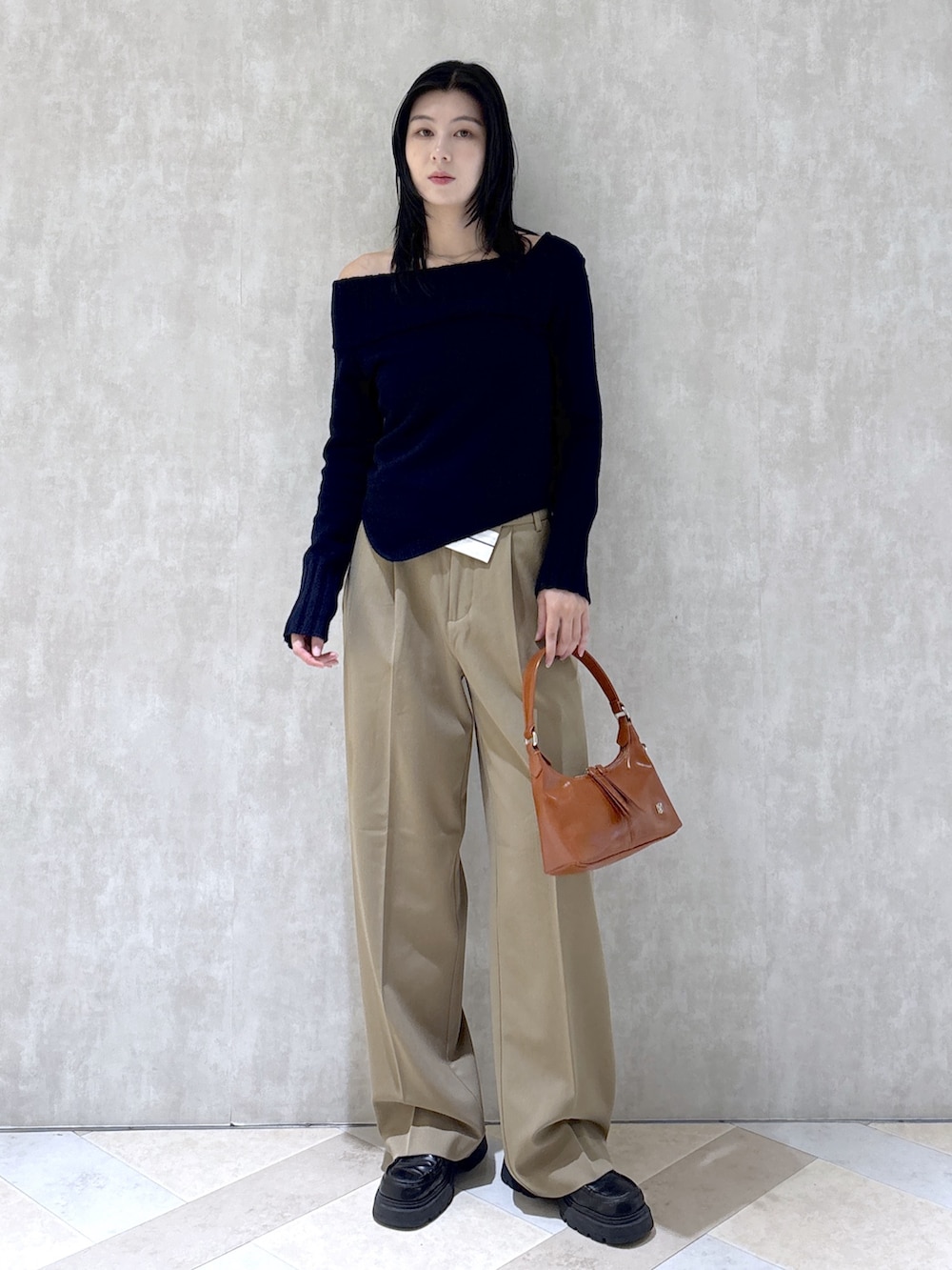 ブルー系のニット/セーター、ベージュ系のその他パンツ、ブラック系のローファーを着用したレディースの秋コーディネートの2枚目の写真