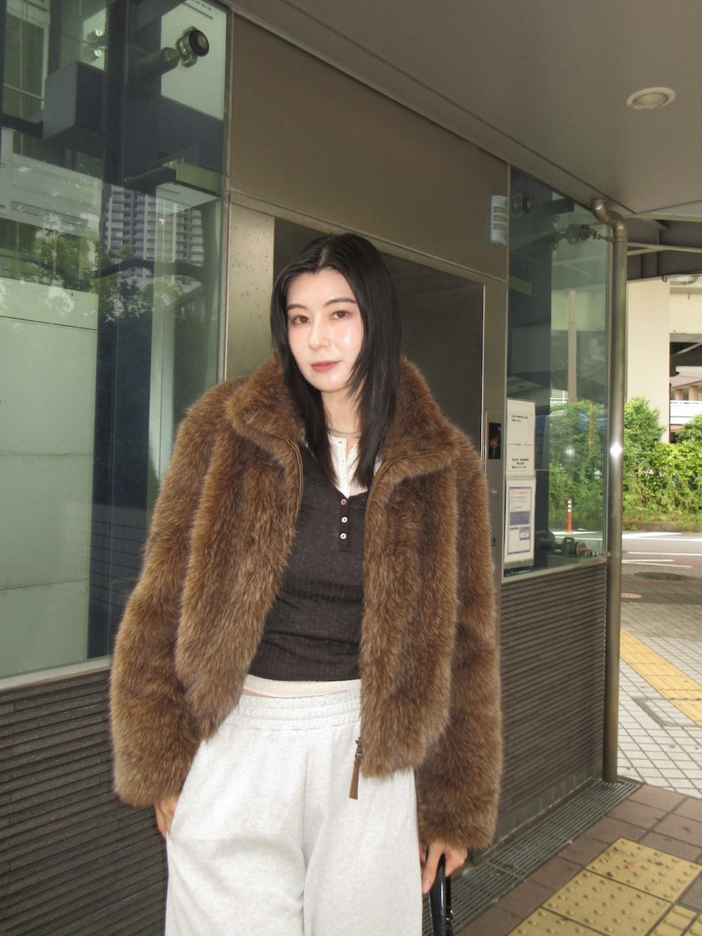 ブラウン系のブルゾン、ホワイト系のニット/セーター、ブラウン系のニット/セーターを着用したレディースの秋コーディネートの3枚目の写真