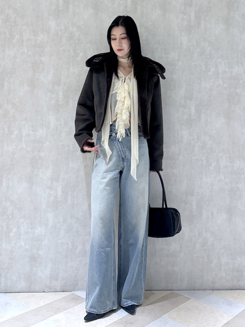 ブラック系のパンプス、ブラック系のショルダーバッグ、ホワイト系のシャツ/ブラウスを着用したレディースの秋コーディネートの2枚目の写真