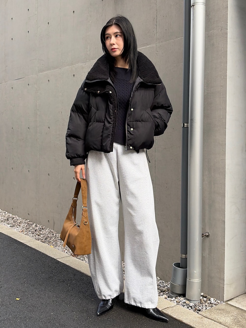 ブラック系のダウンジャケット/コート、グレー系のスウェットパンツ、ブラック系のブーツを着用したレディースの秋コーディネートの5枚目の写真