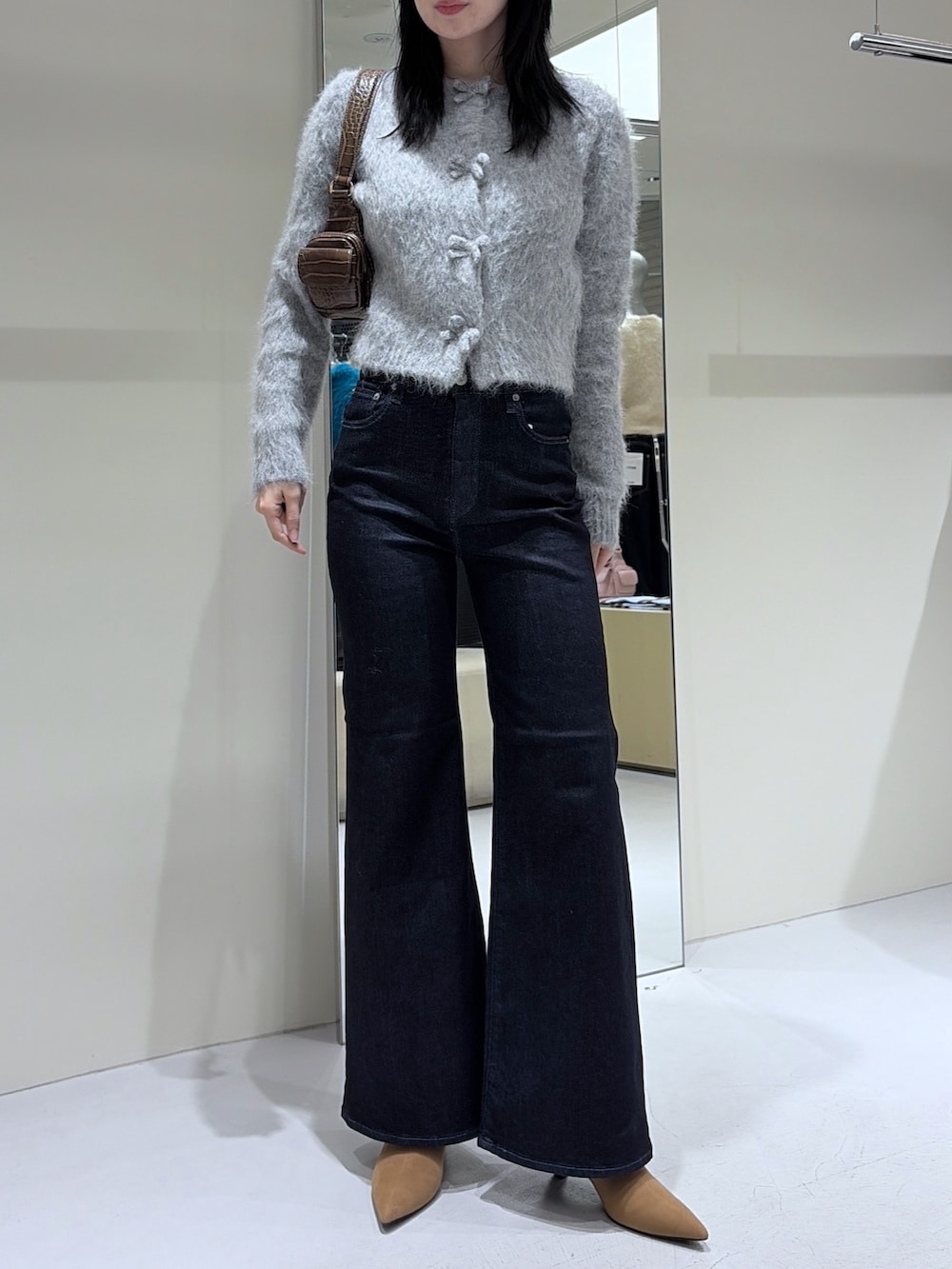 ベージュ系のブーツ、ブルー系のデニムパンツ、グレー系のカーディガン/ボレロを着用したレディースの冬コーディネートの3枚目の写真