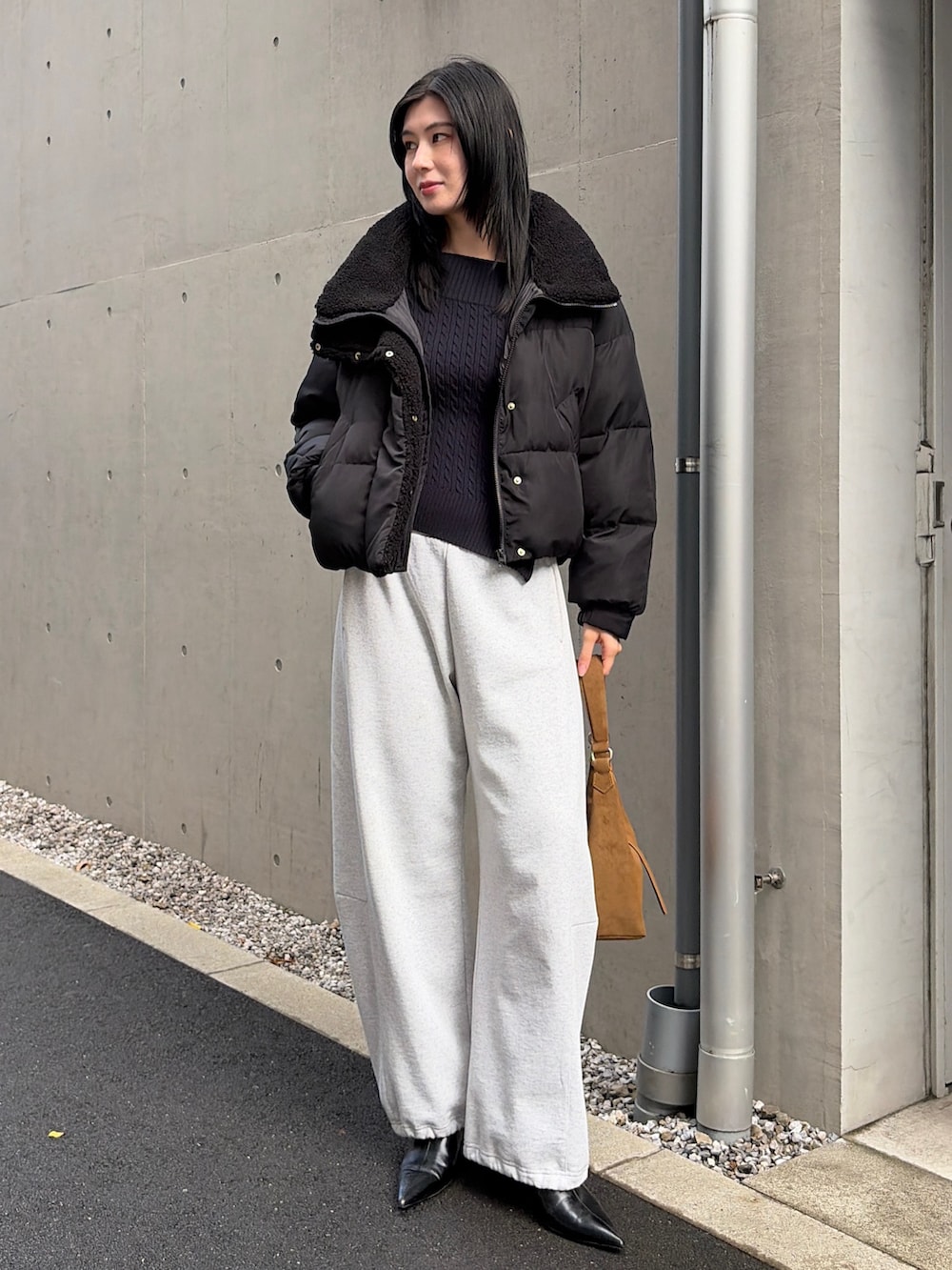 ブラック系のダウンジャケット/コート、グレー系のスウェットパンツ、ブラック系のブーツを着用したレディースの秋コーディネートの2枚目の写真