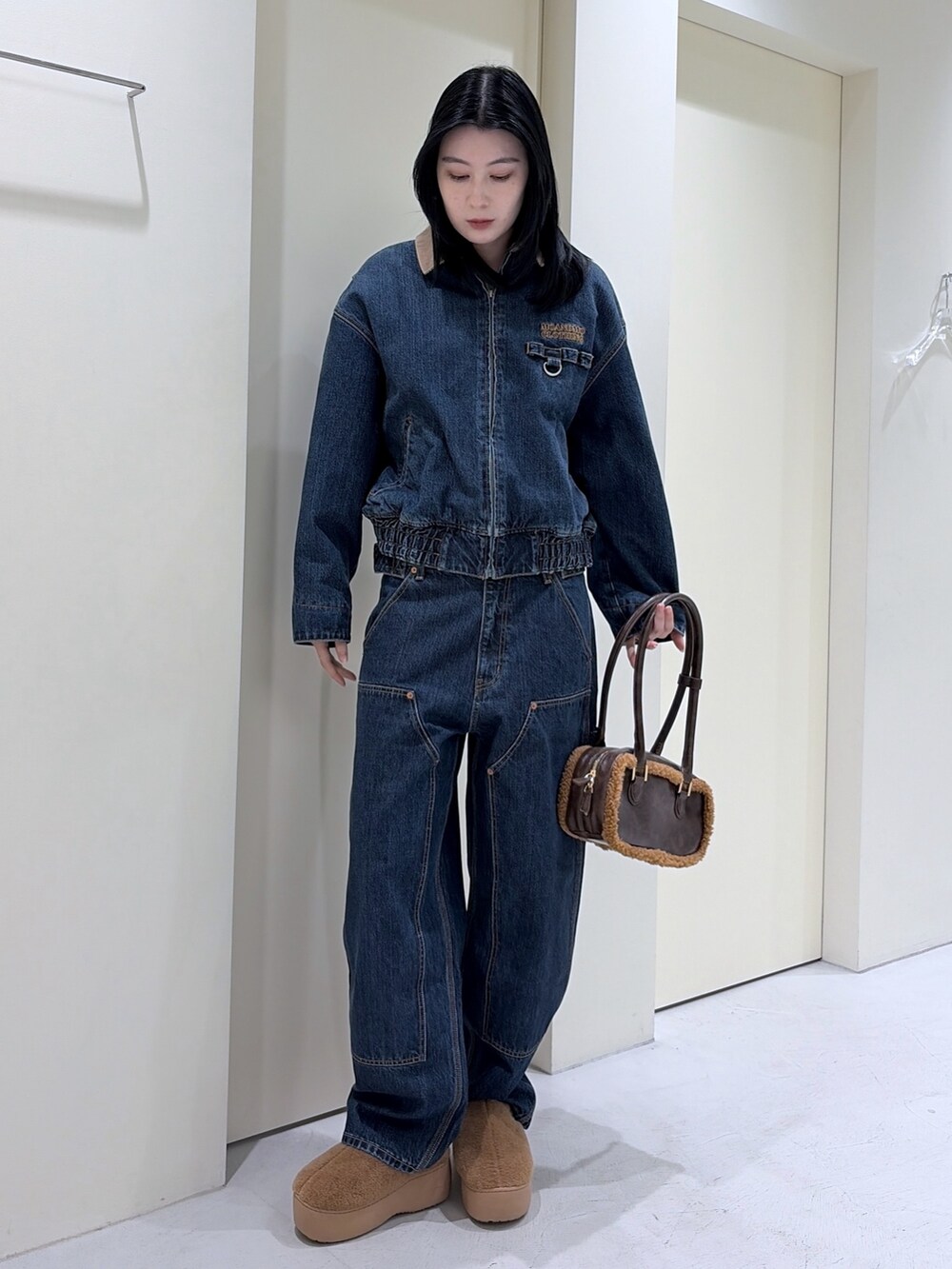 ブルー系のその他アウター、ブルー系のデニムパンツ、ブラウン系のショルダーバッグを着用したレディースの冬コーディネートの3枚目の写真