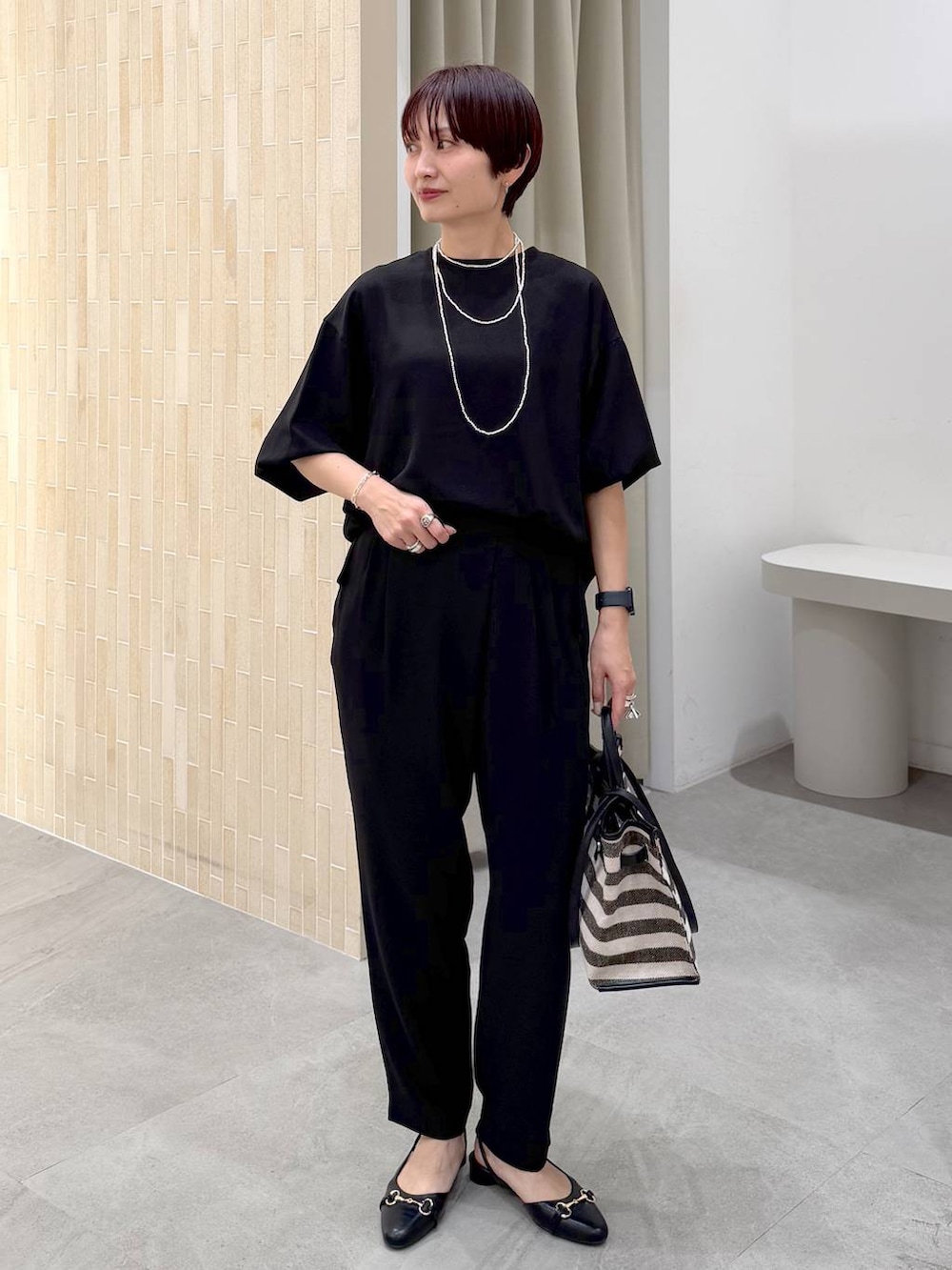 ブラック系のパンプス、ブラック系のトートバッグ、ブラック系のその他パンツを着用したレディースの春コーディネートの2枚目の写真