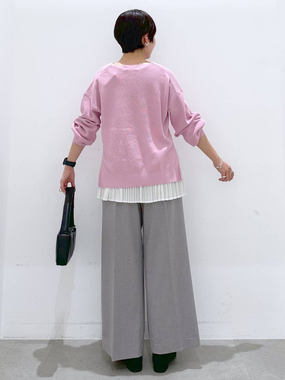 ブラック系のパンプス、ピンク系のニット/セーター、ホワイト系のタンクトップを着用したレディースの冬コーディネートの4枚目の写真