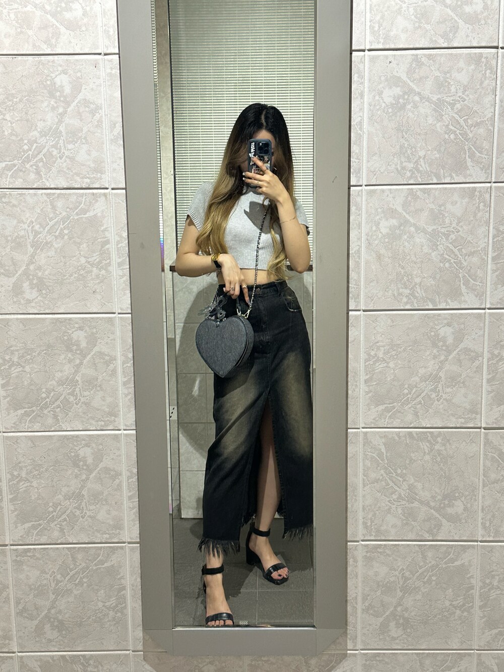 ブラック系のサンダル、ブラック系のデニムスカート、グレー系のニット/セーターを着用したレディースの夏コーディネートの2枚目の写真