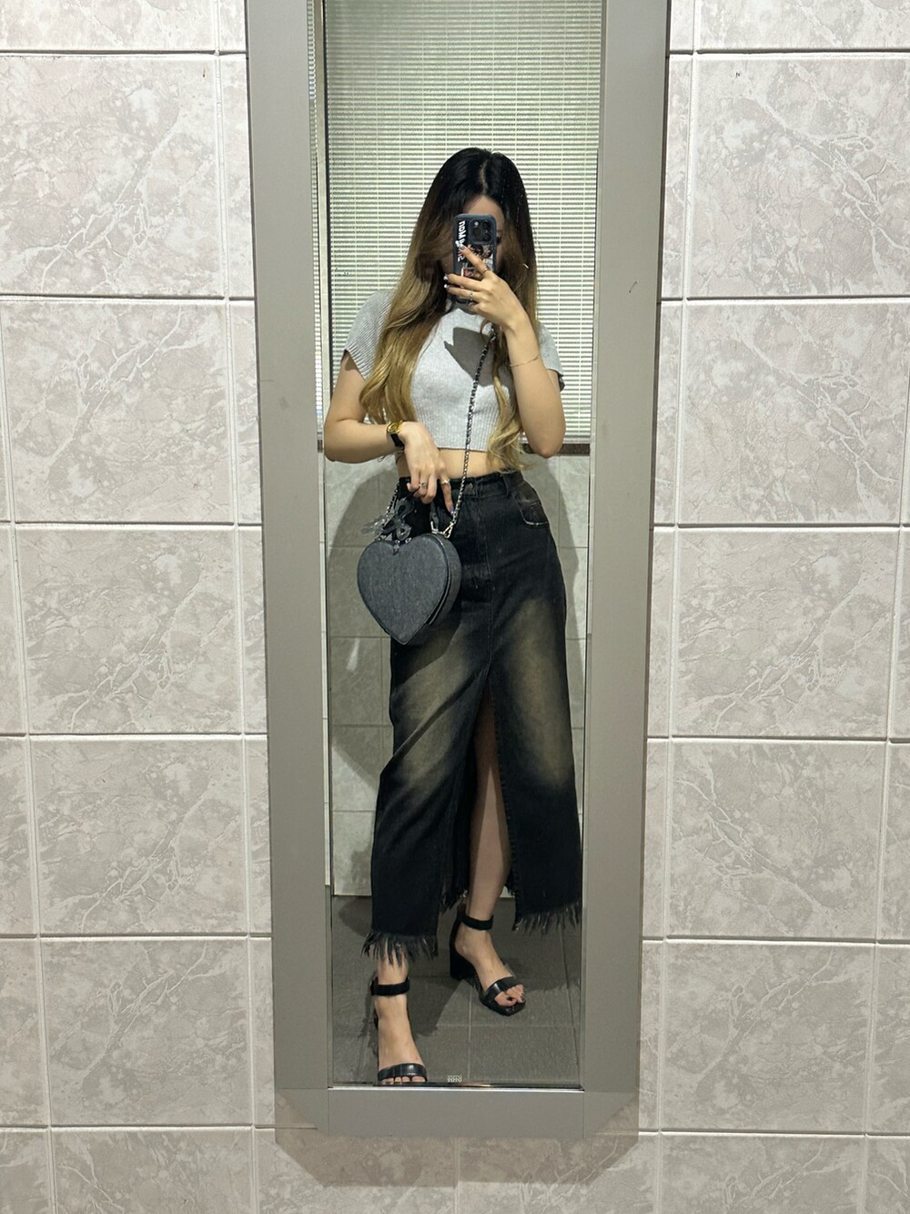 ブラック系のサンダル、ブラック系のデニムスカート、グレー系のニット/セーターを着用したレディースの夏コーディネートの3枚目の写真