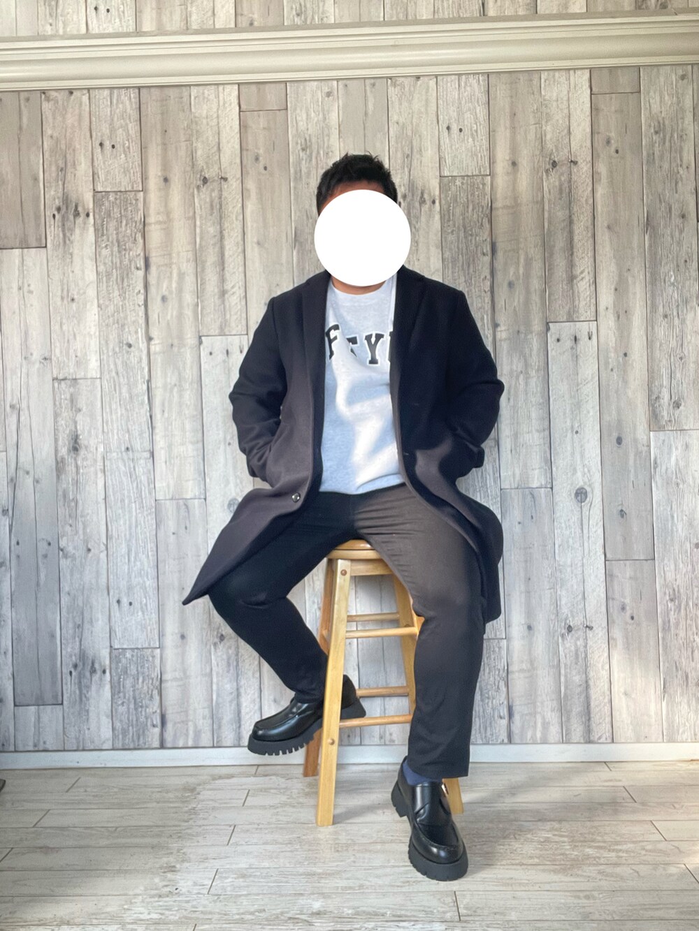 ブルー系のチェスターコート、グレー系のスウェット、ブラック系のパンツを着用したメンズの冬コーディネートの2枚目の写真