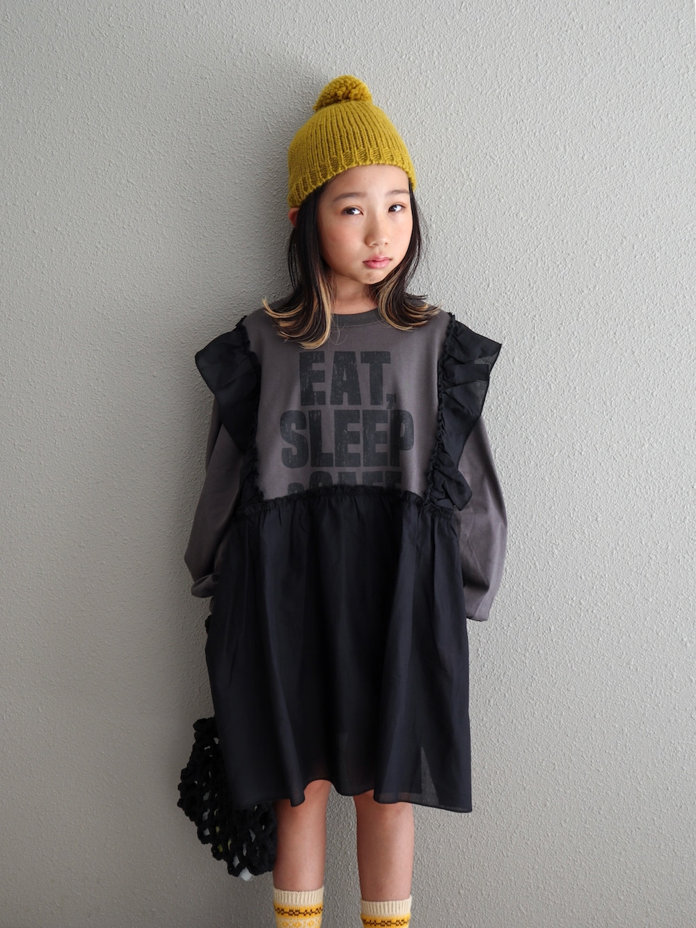 ブラック系のスカート、グレー系のワンピース、ブラック系のサンダルを着用したキッズの秋コーディネートの5枚目の写真