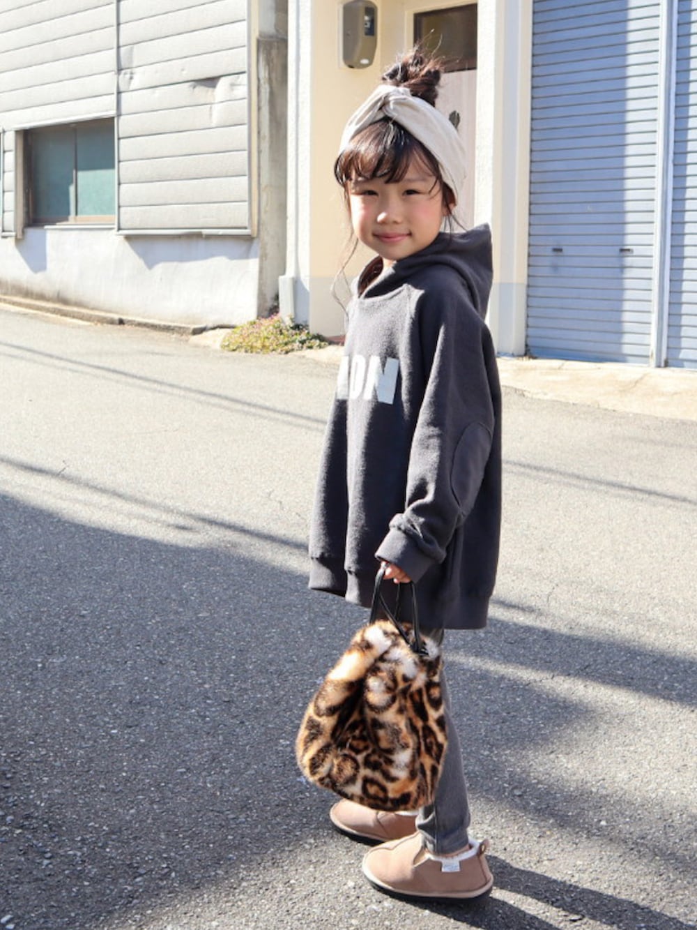 ブラック系のパーカー、ブラック系のデニムパンツ、ベージュ系のブーツを着用したキッズの秋コーディネートの2枚目の写真