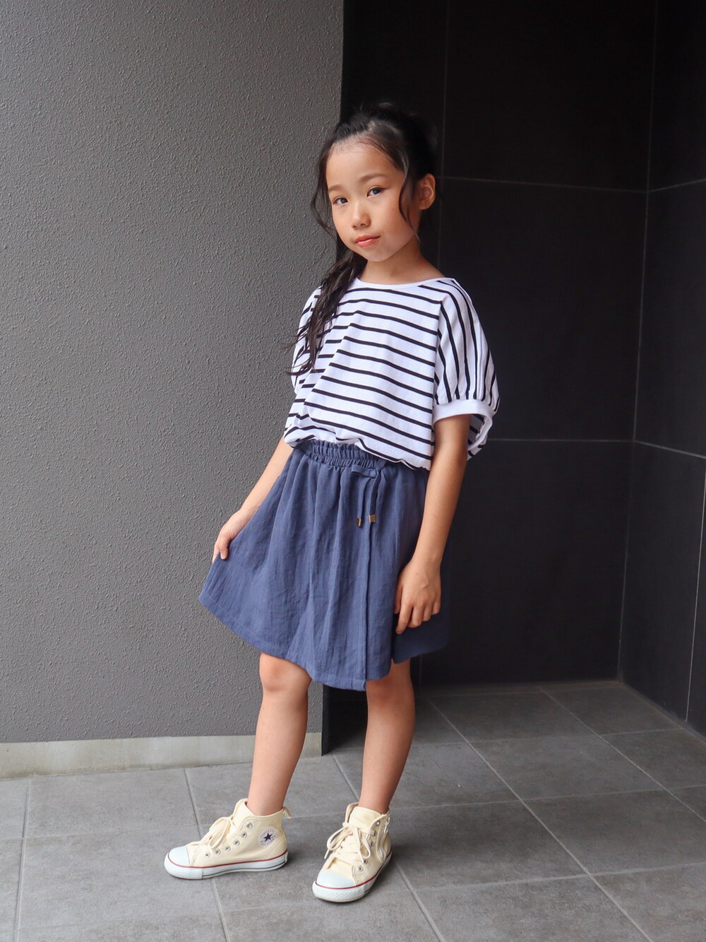 ホワイト系のTシャツ/カットソー、ブルー系のスカート、ホワイト系のスニーカーを着用したキッズの夏コーディネートの2枚目の写真