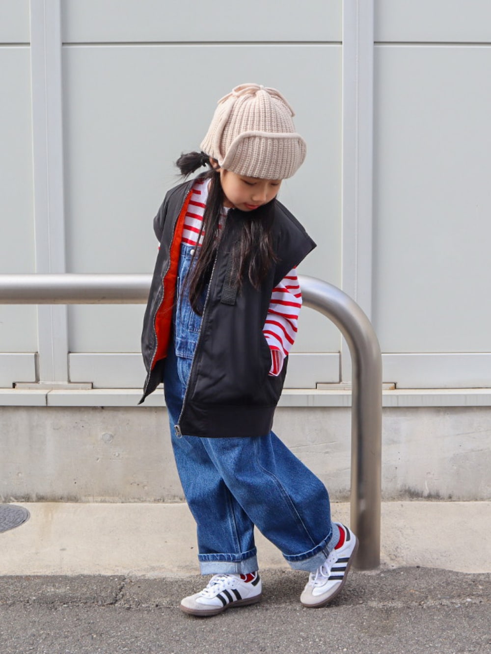 レッド系のTシャツ/カットソー、ブルー系のサロペット/オーバーオール、ブラック系のMA-1を着用したキッズの冬コーディネートの4枚目の写真