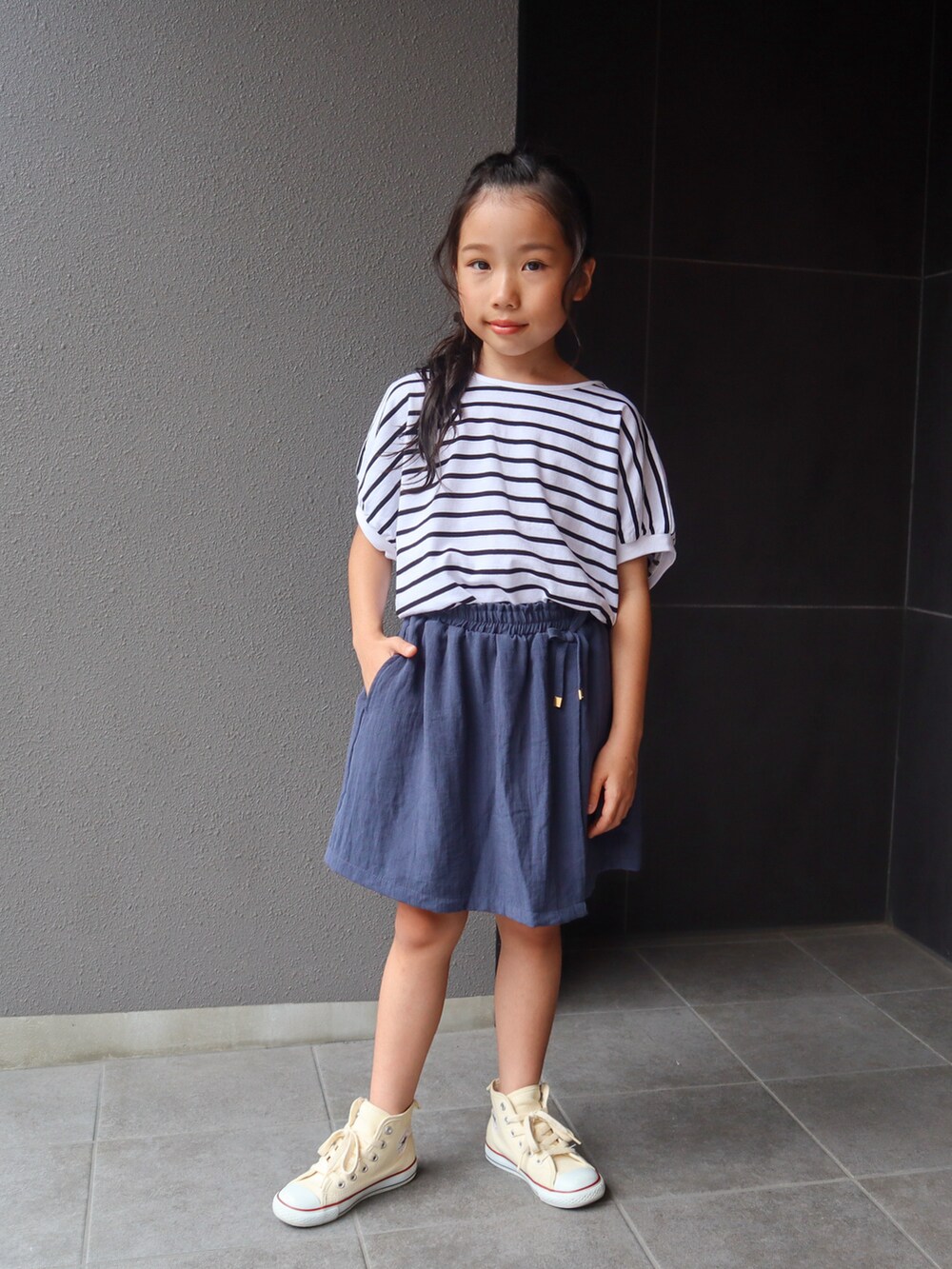 ホワイト系のTシャツ/カットソー、ブルー系のスカート、ホワイト系のスニーカーを着用したキッズの夏コーディネートの4枚目の写真