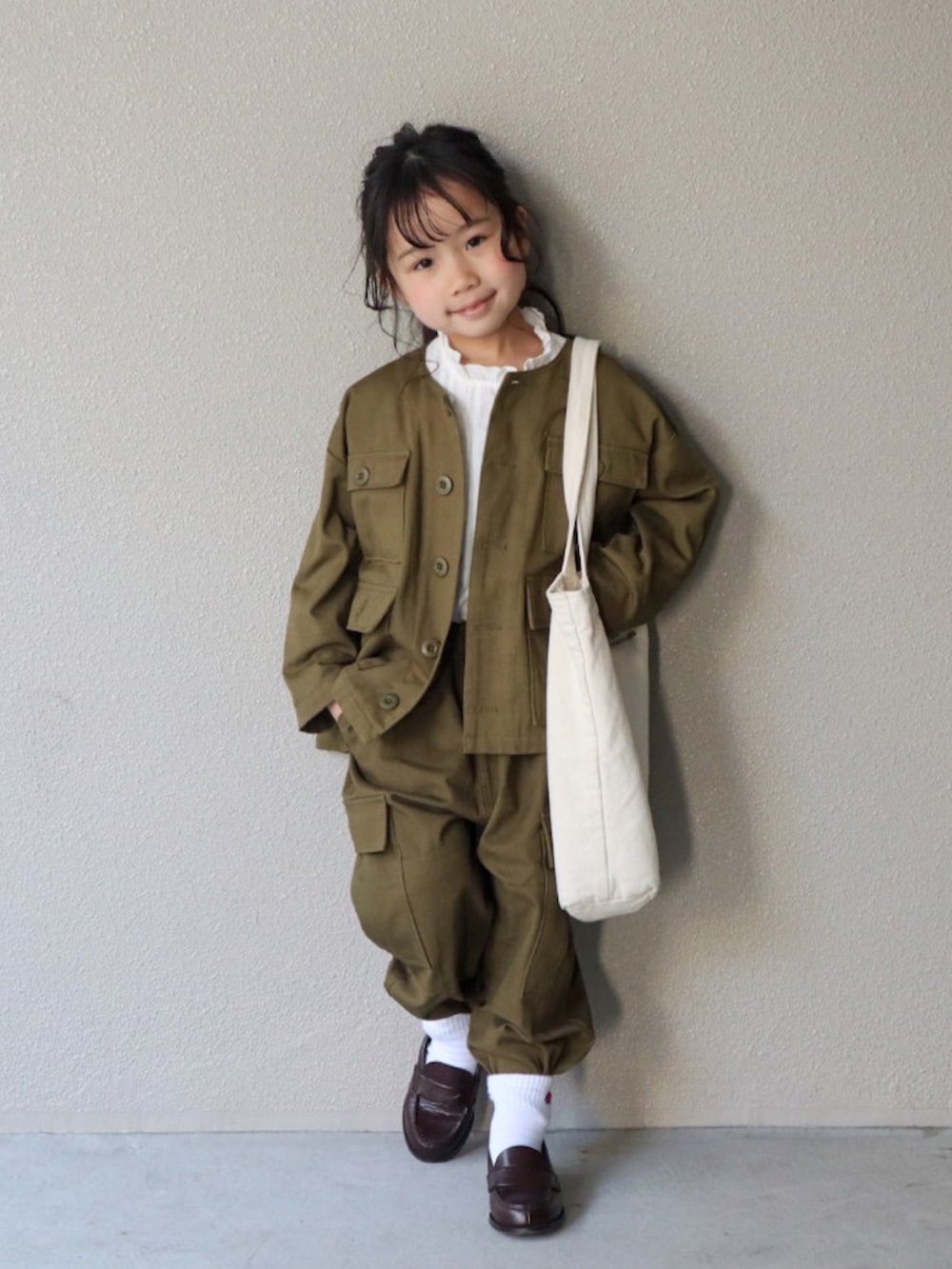 グリーン系のノーカラージャケット、グリーン系のその他パンツ、ホワイト系のシャツ/ブラウスを着用したキッズの春コーディネートの3枚目の写真