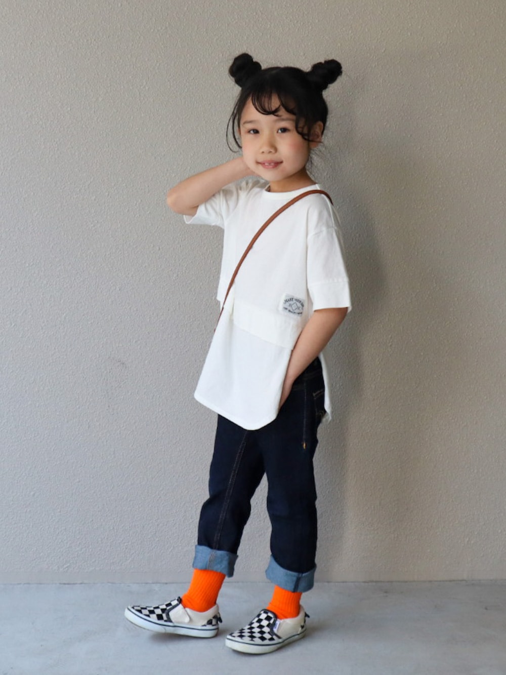 ホワイト系のTシャツ/カットソー、ブルー系のデニムパンツ、ブラック系のスリッポンを着用したキッズの春コーディネートの2枚目の写真