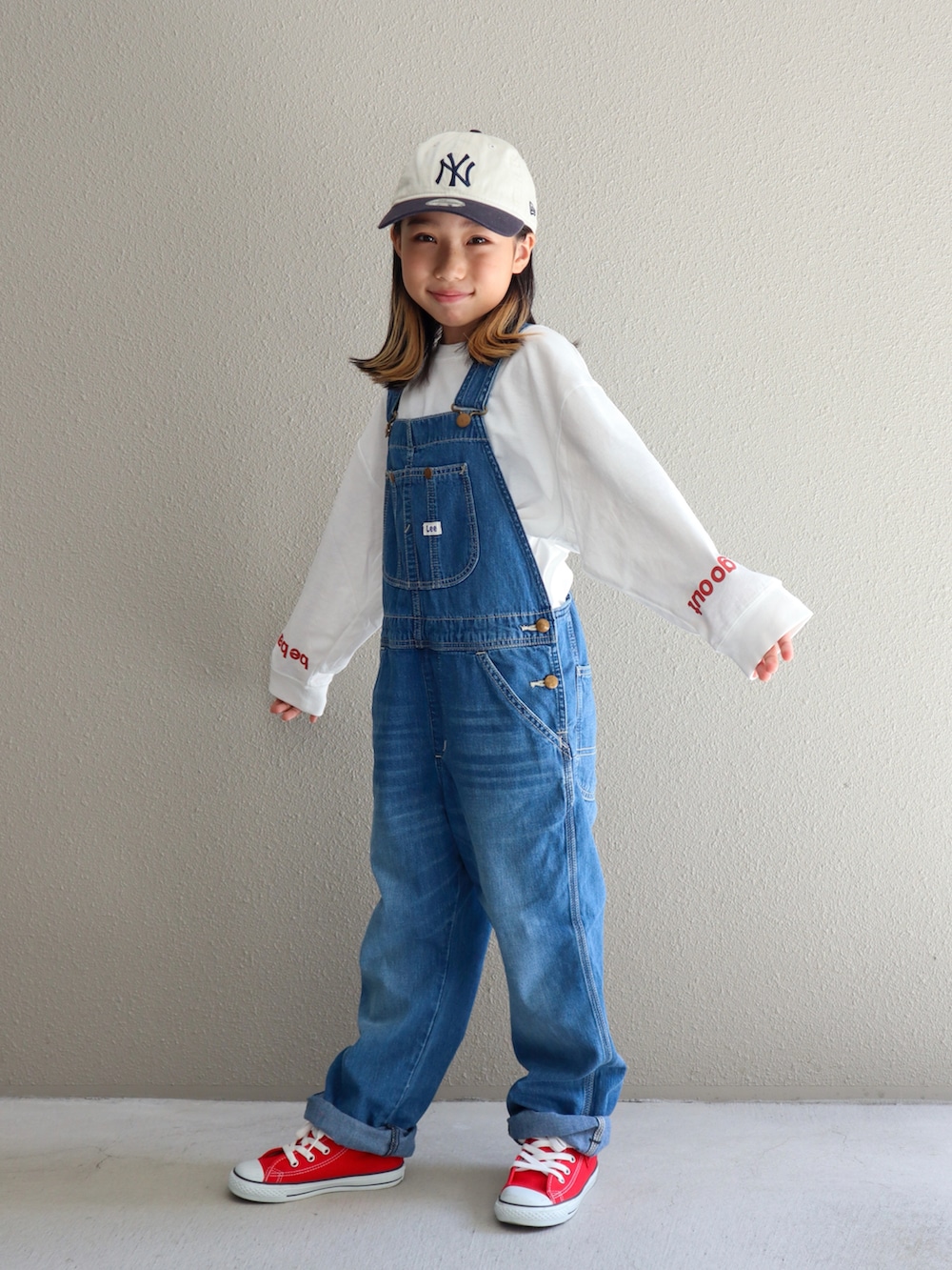 ブルー系のサロペット/オーバーオール、レッド系のスニーカー、ホワイト系のTシャツ/カットソーを着用したキッズの秋コーディネートの4枚目の写真