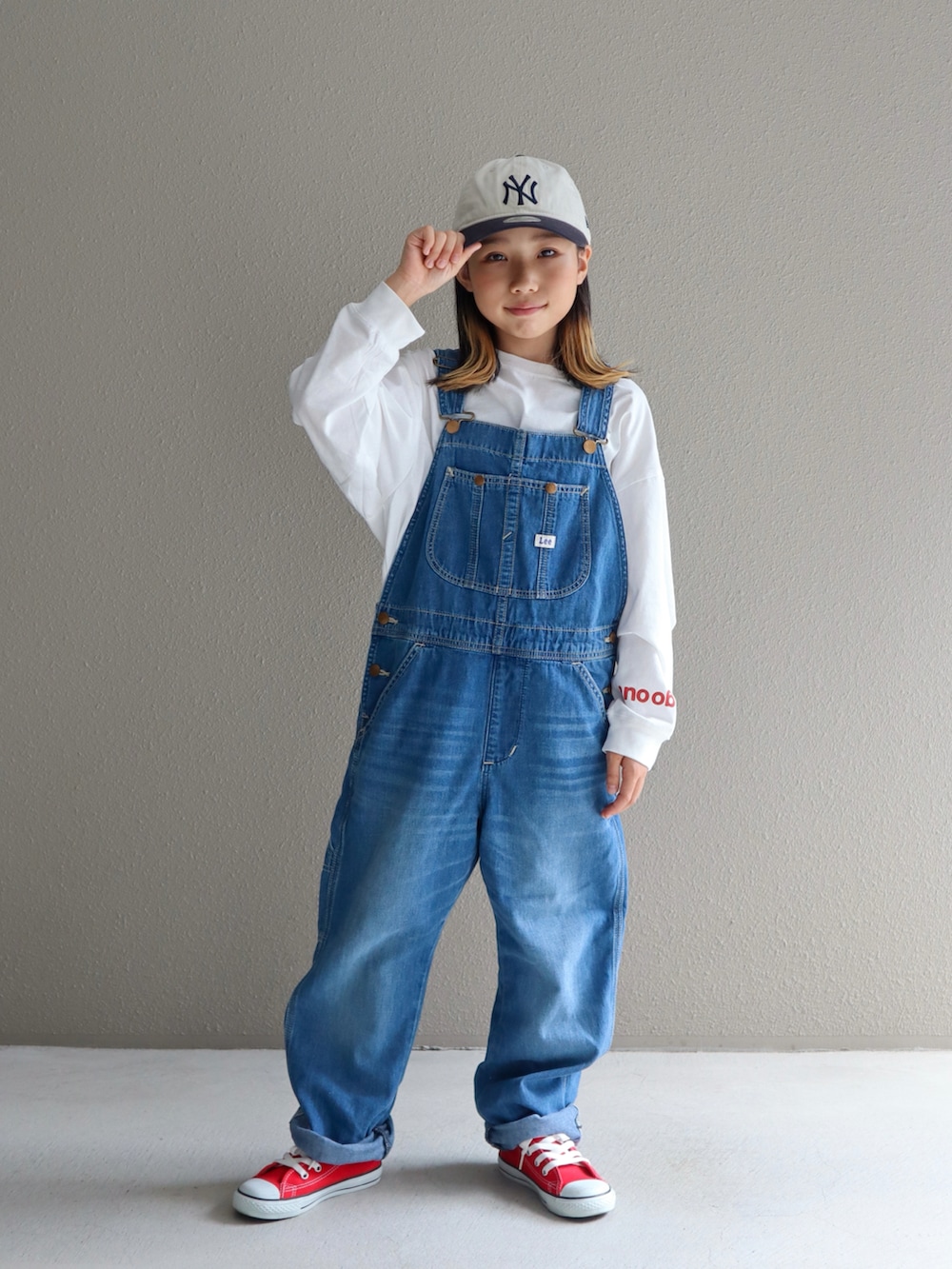 ブルー系のサロペット/オーバーオール、レッド系のスニーカー、ホワイト系のTシャツ/カットソーを着用したキッズの秋コーディネートの2枚目の写真