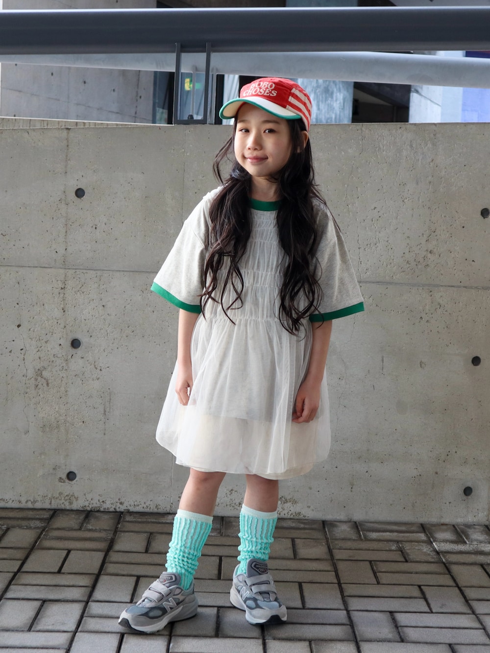 ホワイト系のチュニック、グリーン系のTシャツ/カットソー、ホワイト系のデニムパンツを着用したキッズの春コーディネートの4枚目の写真