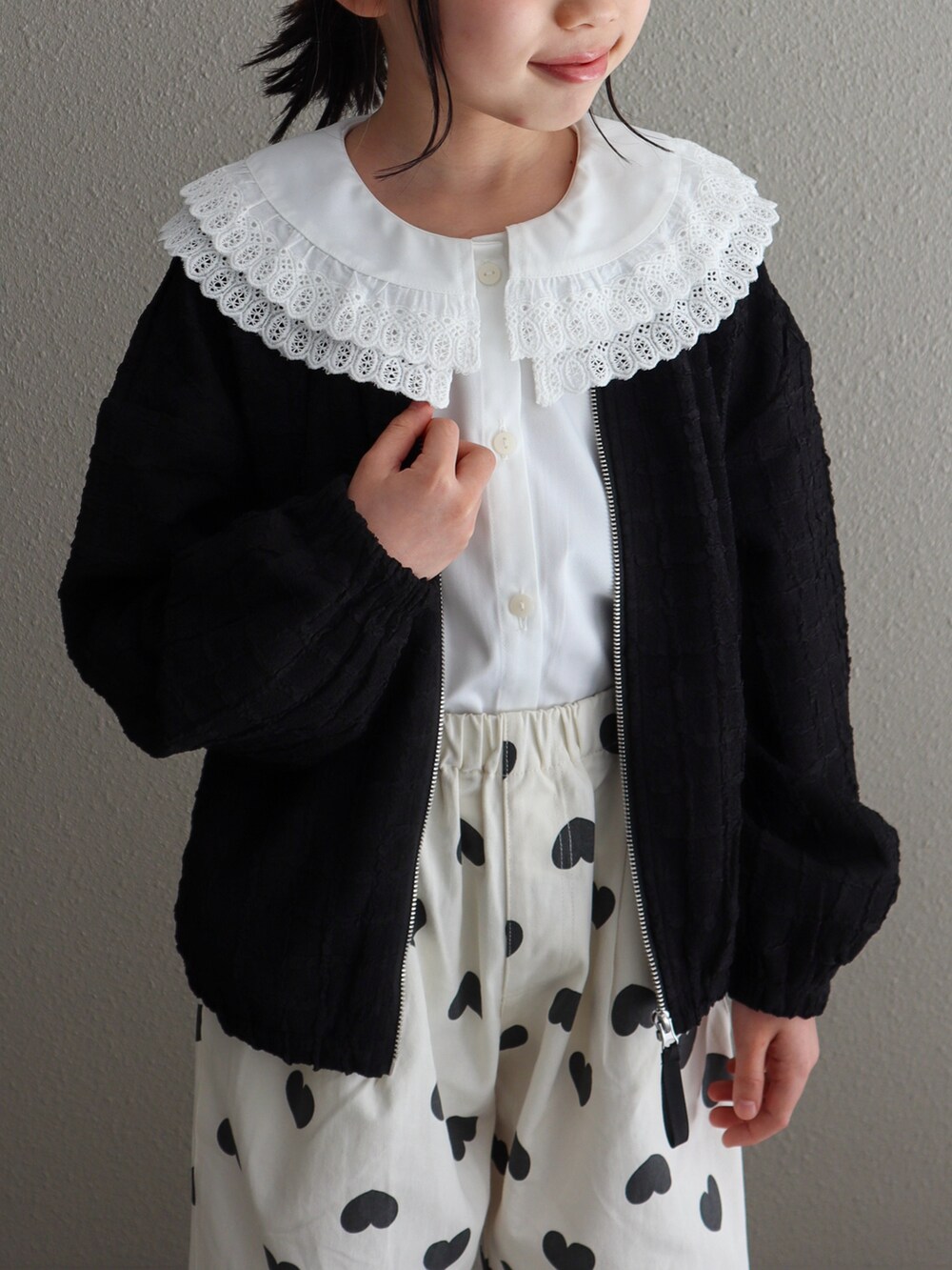 ブラック系のブルゾン、ホワイト系のその他パンツ、ブラック系のシューズを着用したキッズの春コーディネートの4枚目の写真