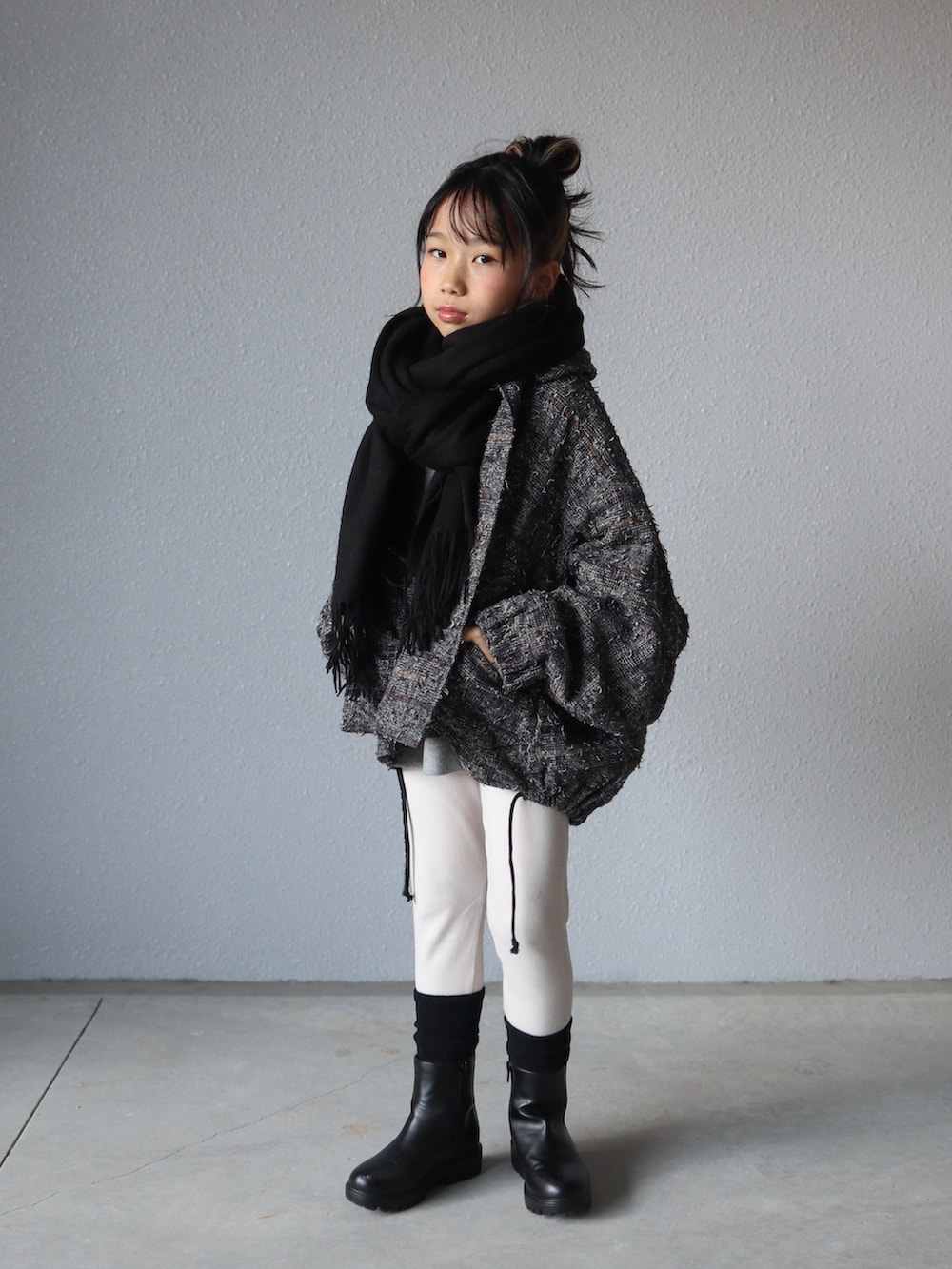 グレー系のスウェット、ブラック系のブーツ、ブラック系のマフラーを着用したキッズの冬コーディネートの4枚目の写真