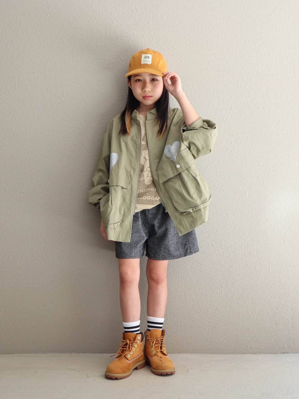 ベージュ系のブーツ、グリーン系のシャツ/ブラウス、ホワイト系のソックス/靴下を着用したキッズの春コーディネートの2枚目の写真