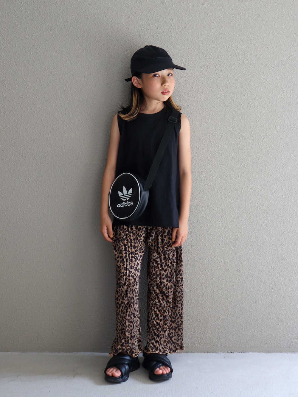 ブラック系のタンクトップ、ブラック系のサンダル、ブラウン系のその他パンツを着用したキッズの夏コーディネートの2枚目の写真