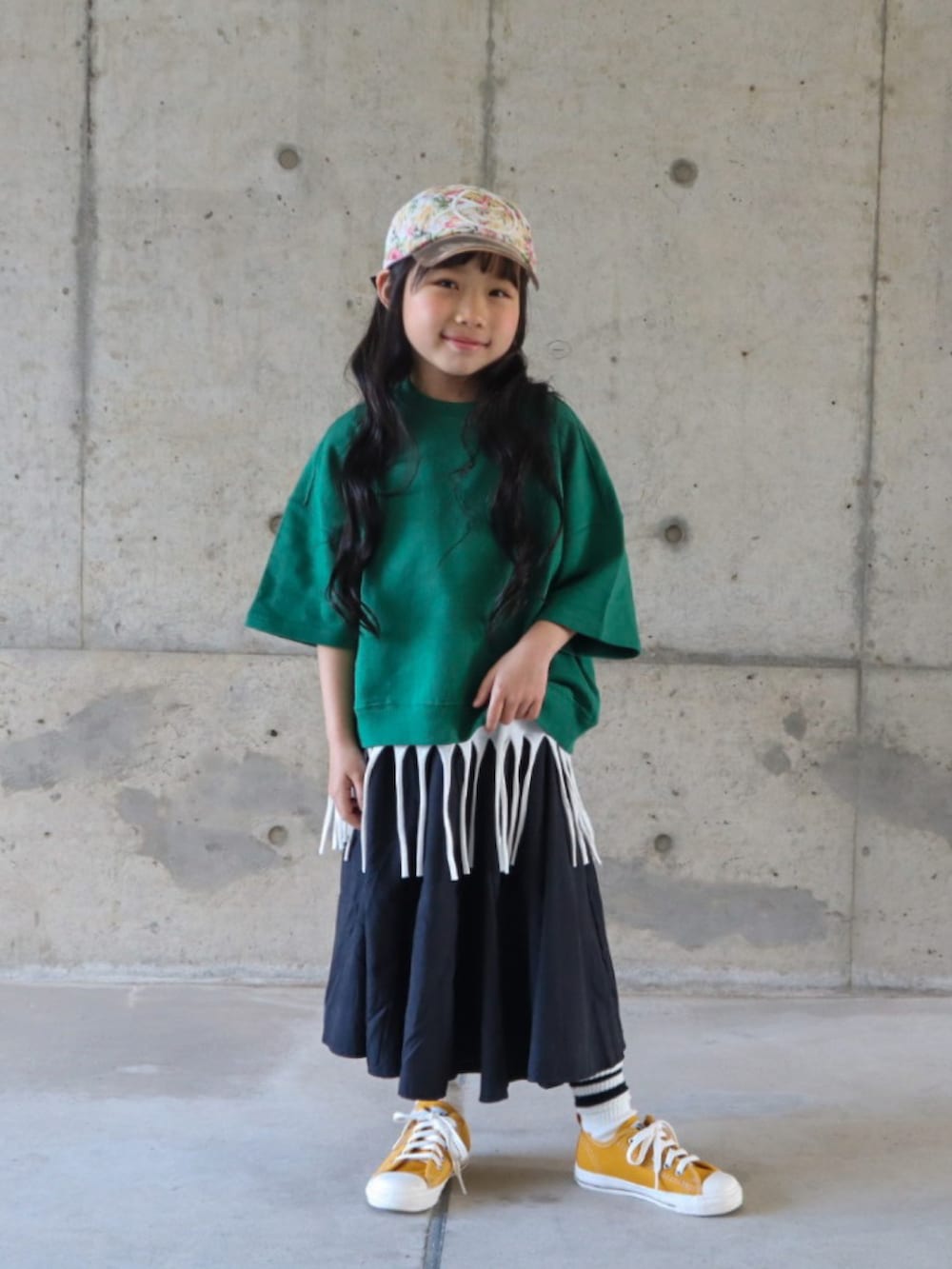 グリーン系のTシャツ/カットソー、ホワイト系のTシャツ/カットソー、ブラック系のスカートを着用したキッズの春コーディネートの3枚目の写真