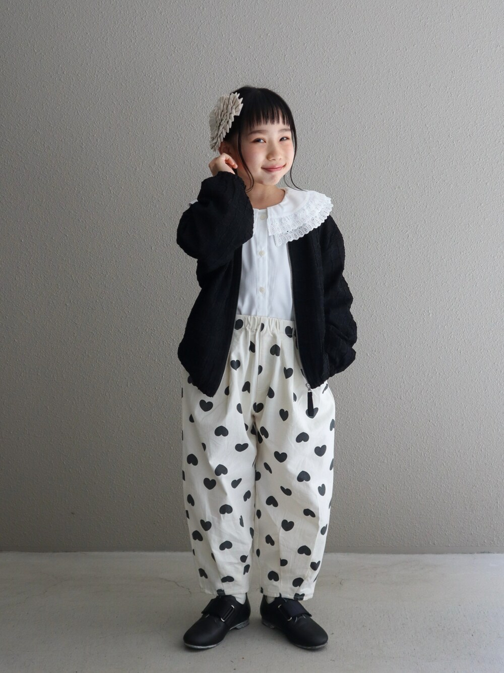 ブラック系のブルゾン、ホワイト系のその他パンツ、ブラック系のシューズを着用したキッズの春コーディネートの3枚目の写真