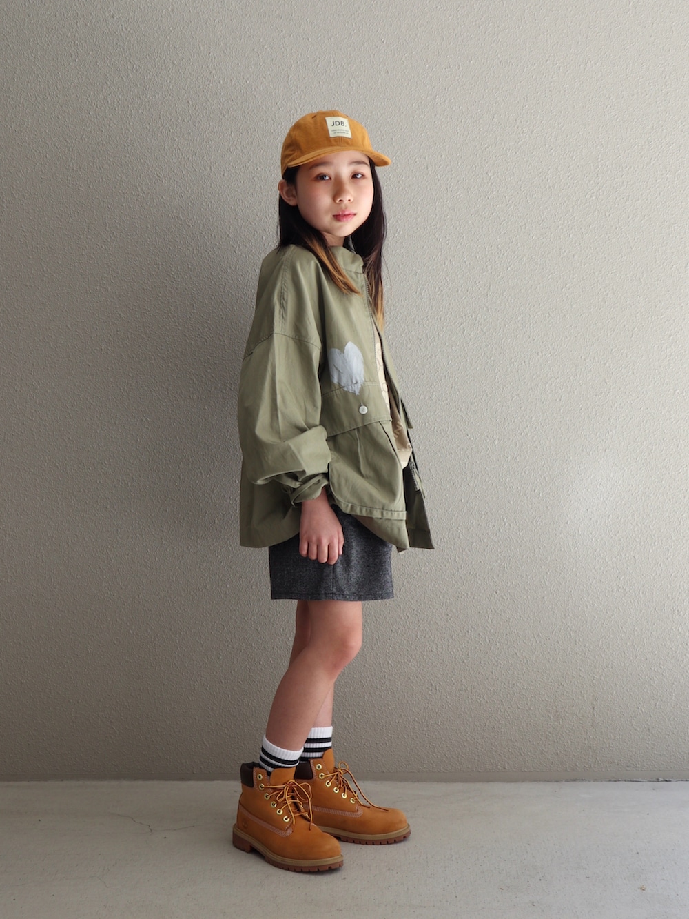 ベージュ系のブーツ、グリーン系のシャツ/ブラウス、ホワイト系のソックス/靴下を着用したキッズの春コーディネートの3枚目の写真