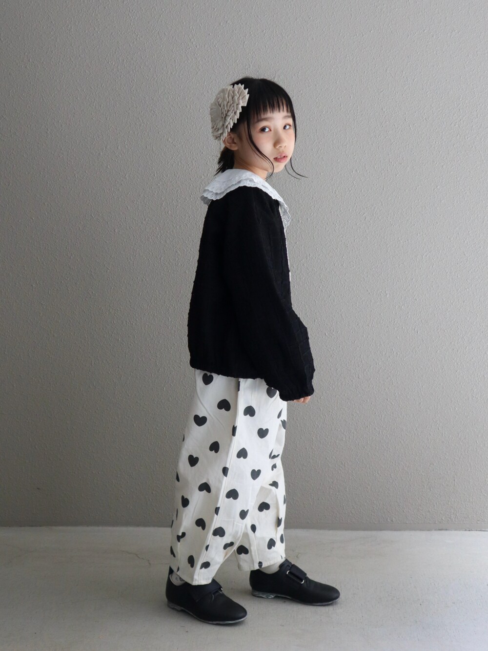 ブラック系のブルゾン、ホワイト系のその他パンツ、ブラック系のシューズを着用したキッズの春コーディネートの2枚目の写真