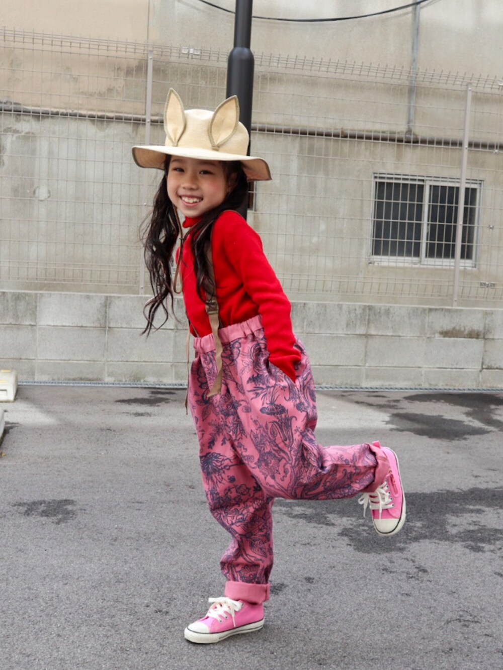 グレー系のMA-1、レッド系のニット/セーター、ピンク系のパンツを着用したキッズの冬コーディネートの3枚目の写真