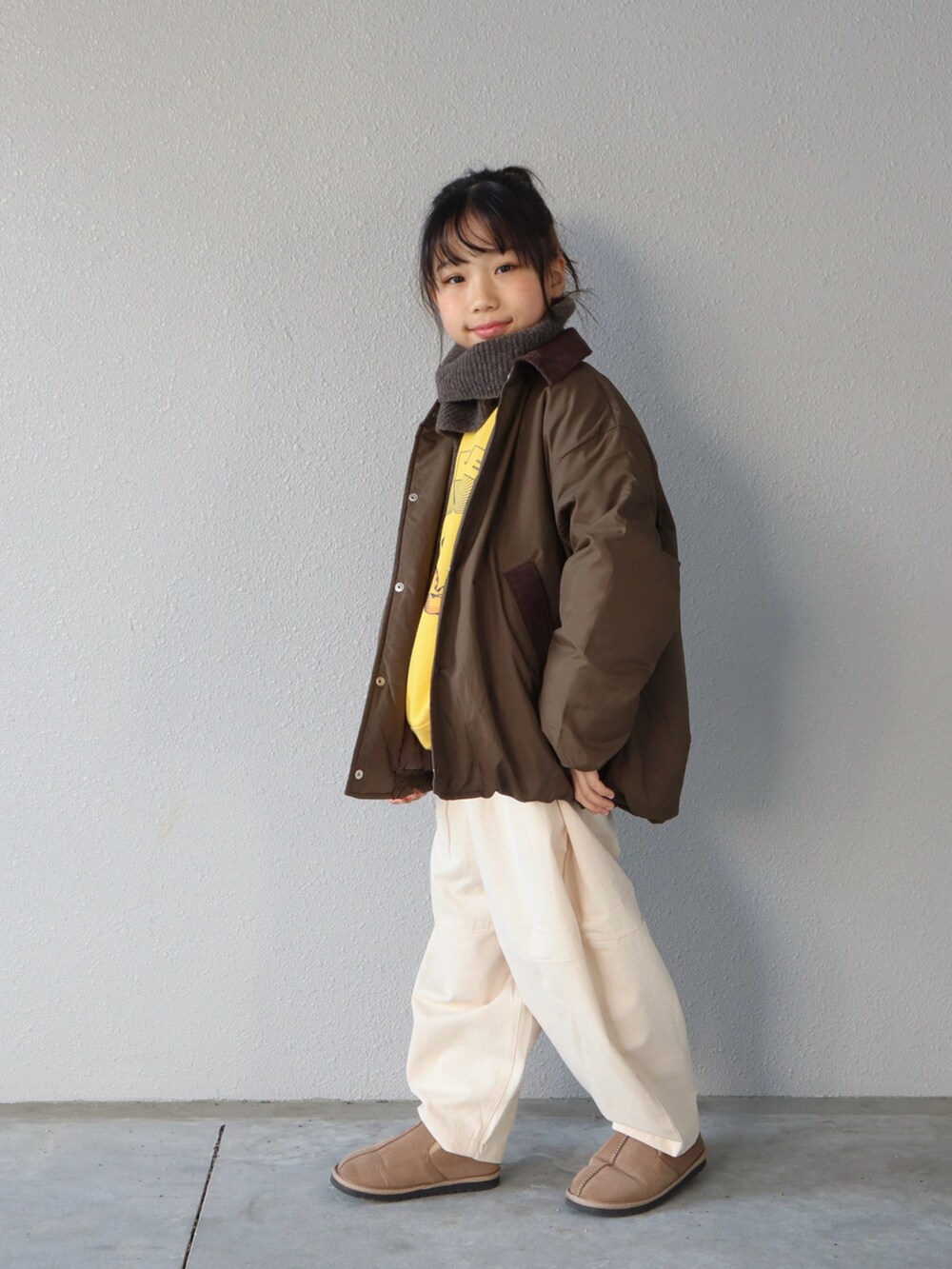 グリーン系のブルゾン、イエロー系のスウェット、ホワイト系のその他パンツを着用したキッズの冬コーディネートの3枚目の写真