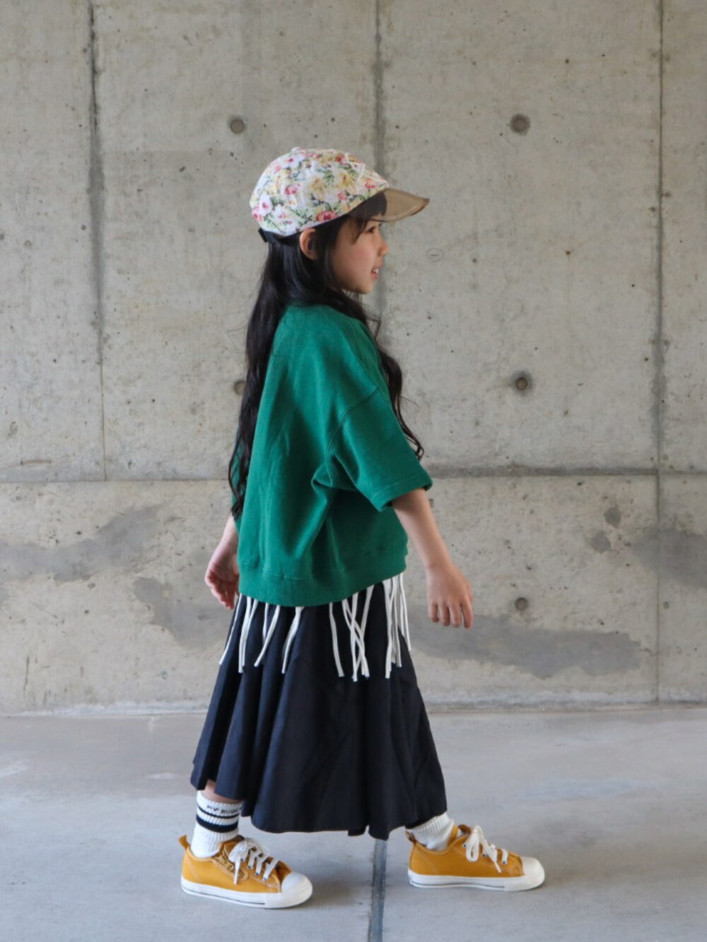 グリーン系のTシャツ/カットソー、ホワイト系のTシャツ/カットソー、ブラック系のスカートを着用したキッズの春コーディネートの2枚目の写真