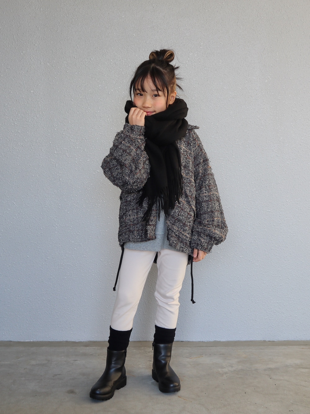 グレー系のスウェット、ブラック系のブーツ、ブラック系のマフラーを着用したキッズの冬コーディネートの2枚目の写真