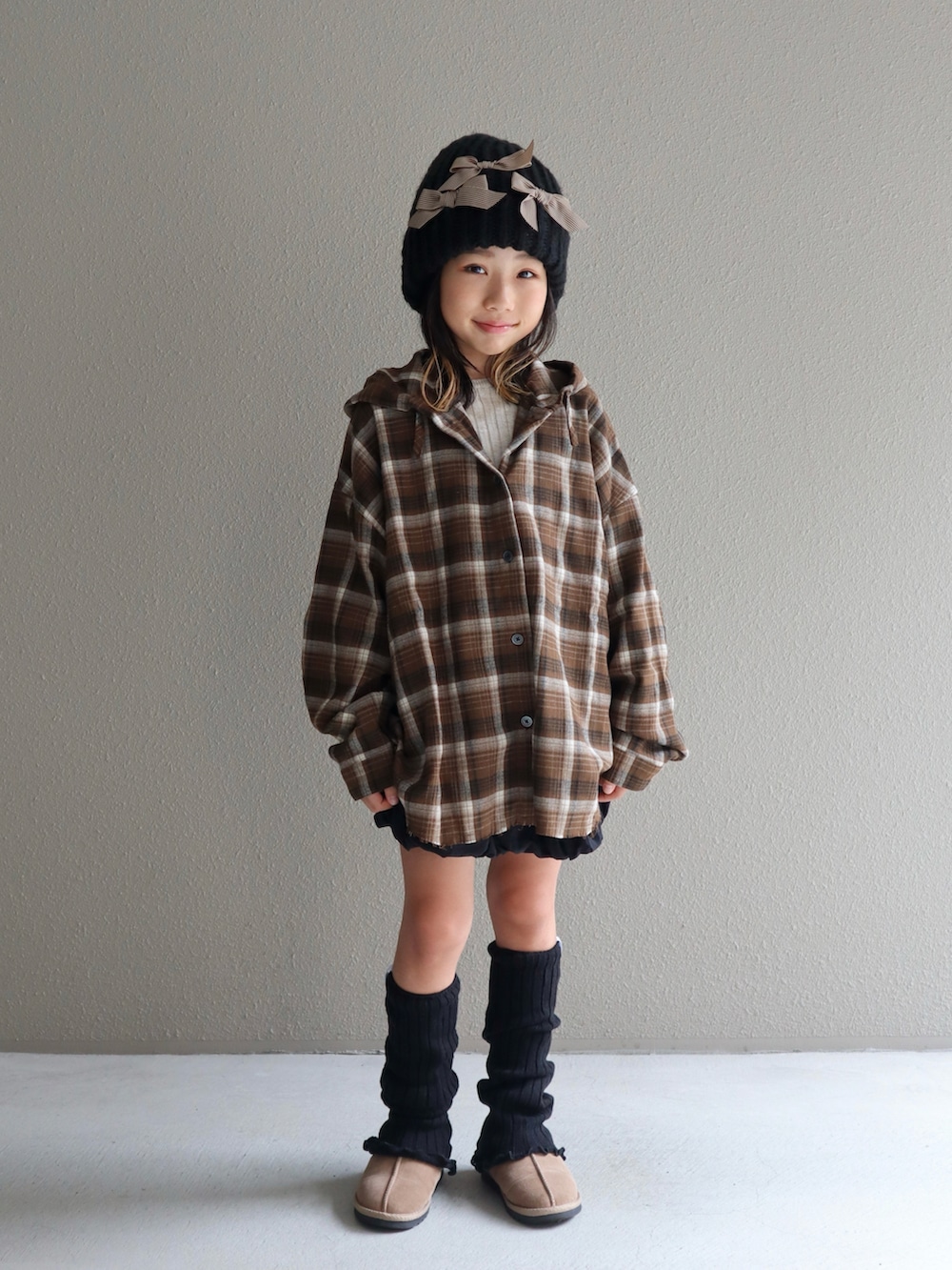 ブラウン系のシャツ/ブラウス、ブラック系のスカート、ベージュ系のブーツを着用したキッズの秋コーディネートの2枚目の写真