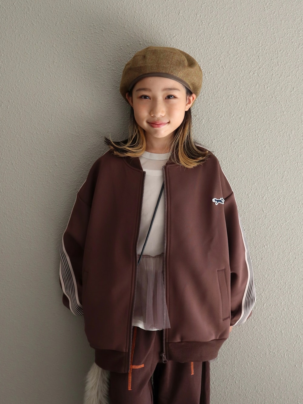 ブラウン系のジャケット/アウター、ブラウン系のパンツ、ベージュ系のサンダルを着用したキッズの秋コーディネートの3枚目の写真