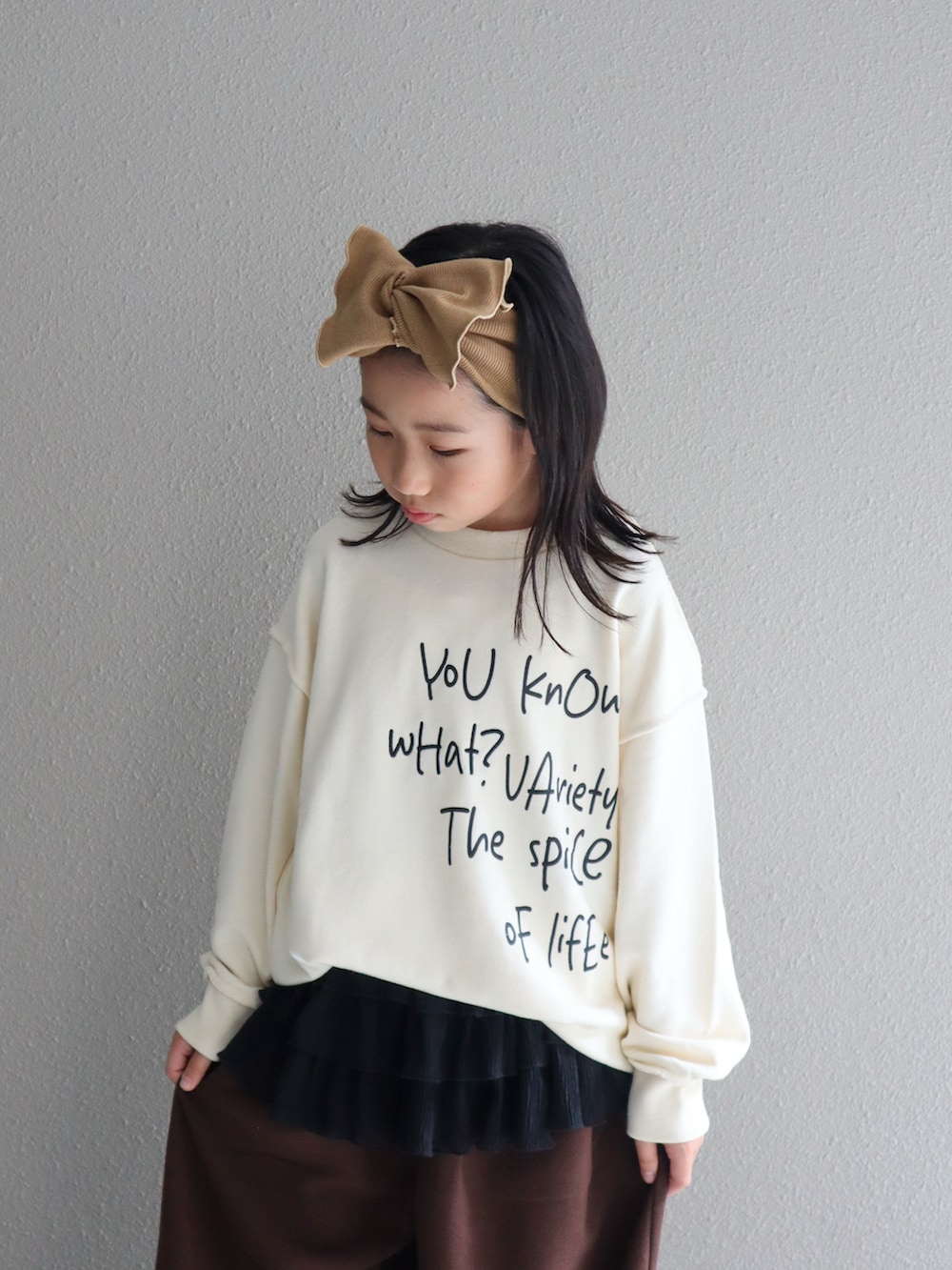 ホワイト系のTシャツ/カットソー、ブラウン系のその他パンツ、ブラック系のスカートを着用したキッズの秋コーディネートの3枚目の写真