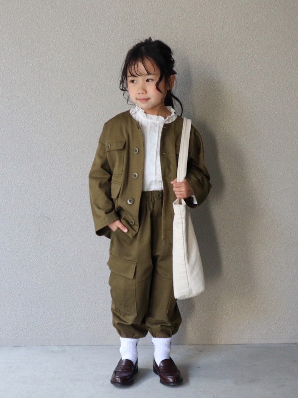 グリーン系のノーカラージャケット、グリーン系のその他パンツ、ホワイト系のシャツ/ブラウスを着用したキッズの春コーディネートの2枚目の写真