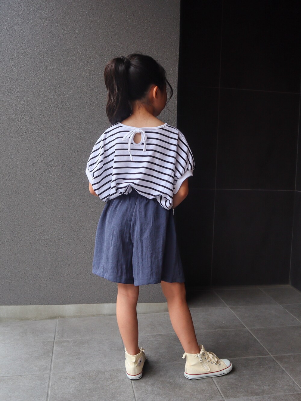ホワイト系のTシャツ/カットソー、ブルー系のスカート、ホワイト系のスニーカーを着用したキッズの夏コーディネートの5枚目の写真